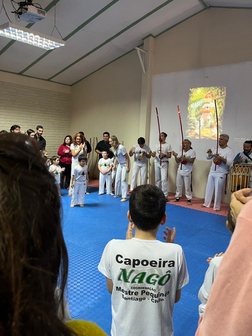 Roda de capoeira con berimbaus en la sala