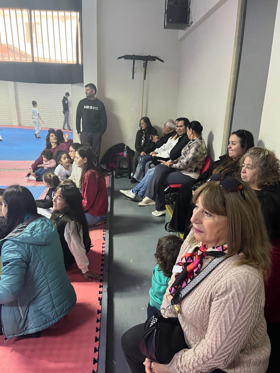 Apoderados y familias mirando una muestra en el dojo