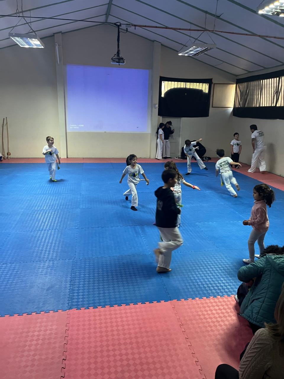 Niños y niñas corriendo sobre el tatami en una clase infantil